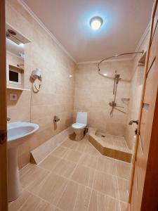 łazienka z wanną, toaletą i umywalką w obiekcie Райский Дворик w mieście Pogreby