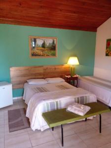 a bedroom with two beds and a table with a lamp at Pousada Desfiladeiro da Serra in Serra Negra