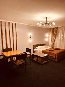 ein Hotelzimmer mit einem Bett, einem Tisch und Stühlen in der Unterkunft Райский Дворик in Pogreby