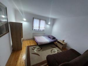 um pequeno quarto com uma cama e um tapete em Foča-Dragočava em Foca