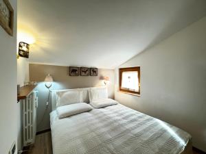 a bedroom with a white bed with two pillows at Liuby Home in Sestriere