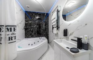 a white bathroom with a tub and a sink at MYFREEDOM Апартаменти пр-т Правди 6 in Kyiv