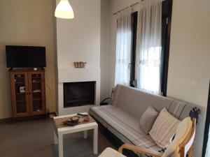 a living room with a couch and a tv at green guesthouse in Komotini