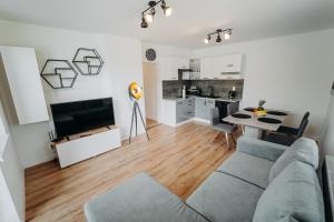 a living room with a couch and a table and a kitchen at Double Floor Apartment With 2 Terraces in Veľká Lomnica