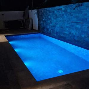 a swimming pool with blue lighting in a room at Marrakech villa avec piscine privée 4 chambres 4 salles de bains in Marrakesh