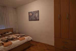 a bedroom with a bed and a painting on the wall at Apartman TWO 