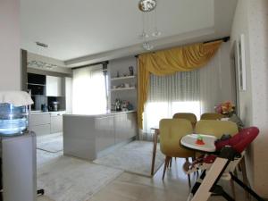 a kitchen and a dining room with a table and chairs at Lüks Rezidansta Modern Daire in Antalya