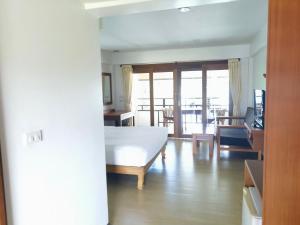 拉威海灘的住宿－Phuket Meet Holiday Hotel 普吉岛相遇酒店，一间卧室设有一张床和一间客厅。