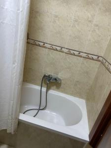 a bath tub with a hose in a bathroom at El-Shaikh Zayed, 6 october 3BHK flat- families only in Sheikh Zayed
