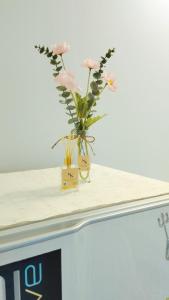 a vase with pink flowers sitting on a counter at NK hostel P2 16/30 in Ban Song Hong