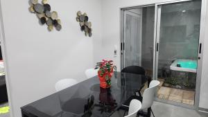 comedor con mesa de cristal y sillas blancas en Casa Mariposa en Herradura