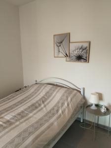a bedroom with a bed with two pictures on the wall at green guesthouse in Komotini