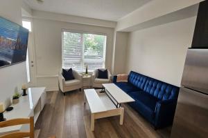 a living room with a blue couch and chairs at Entire 2 Bedroom Townhouse in Toronto! in Toronto