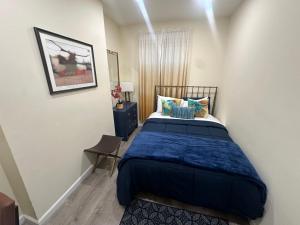 a bedroom with a bed with a blue comforter at Upscale Super LUX Private 2br Near NYC in New Rochelle