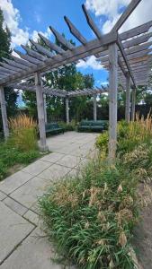 a wooden pergola with benches in a garden at Entire 2 Bedroom Townhouse in Toronto! in Toronto