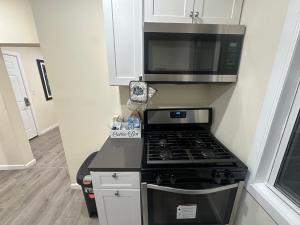 a kitchen with a stove and a microwave at Upscale Super LUX Private 2br Near NYC in New Rochelle