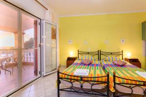 een slaapkamer met een bed en een balkon bij Beachfront House Tolis - Pelekas Beach in Pelekas