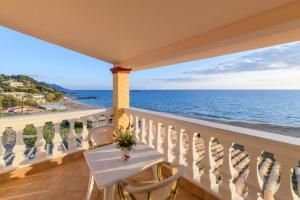een balkon met een tafel en stoelen en de oceaan bij Beachfront House Tolis - Pelekas Beach in Pelekas +25 foto's