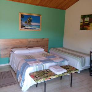 2 camas en una habitación con paredes verdes en Pousada Desfiladeiro da Serra, en Serra Negra