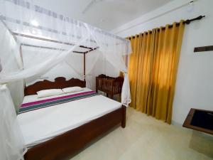 1 dormitorio con 1 cama con dosel en Thotupola Villa - Mirissa, en Mirissa