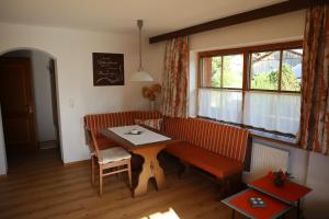 ein Wohnzimmer mit einem Sofa, einem Tisch und einem Fenster in der Unterkunft Haus Moosbrunn in Alpbach