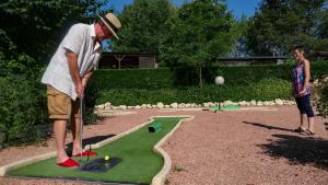 a man playing golf with a miniature golf course at Camping Les Lacs de Courtès in Estang