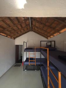 a room with two bunk beds and a wooden ceiling at Revibe Beach Hostel Gokarna in Gokarna