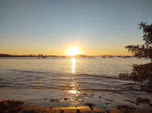 einen Sonnenuntergang über einem Wasserkörper in der Unterkunft Apartamento na praia - Canto da Sereia in Piçarras