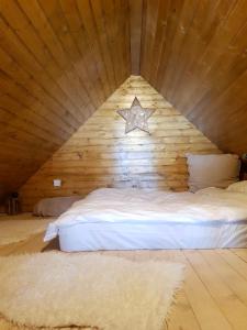 Cama en habitación de madera con una estrella en la pared en Zlatibor Sky Inn en Zlatibor
