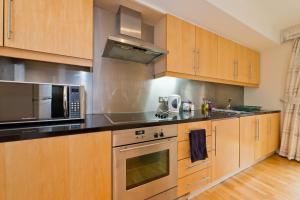 una cocina con electrodomésticos de acero inoxidable y armarios de madera en Dublin City Retreat, en Dublín