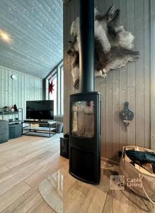 ein Wohnzimmer mit einem Kamin und einem TV in der Unterkunft New cabin near X Country ski trails at Blefjell with Jacuzzi in Flesberg