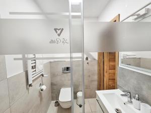 biała łazienka z toaletą i umywalką w obiekcie APARTAMENTY "LA VILLA" z klimatyzacją, ogrodem i parkingiem w Kudowie Zdroju