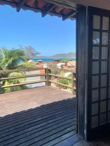 una puerta abierta a una terraza con vistas al océano en Aldeia de Geribá - Jardim, piscina e praia, en Búzios