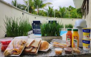 a table with bread and drinks and food on it at Pousada Boutique Três Marias in Guarujá