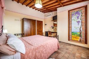 1 dormitorio con 1 cama y una pintura en la pared en Agriturismo Cesani, en San Gimignano