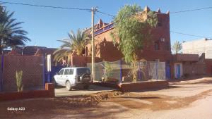 ein weißes Auto, das vor einem Zaun parkt in der Unterkunft Maroc Galacx in Ouarzazate