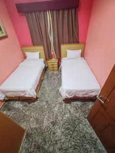 two beds in a room with pink walls at منتجع الريحانه فله رقم 1 in Taif