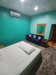 a bedroom with a large bed and a blue wall at منتجع الريحانه فله رقم 1 in Taif