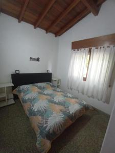 ein Schlafzimmer mit einem Bett mit einer bunten Bettdecke in der Unterkunft Casasodali in Villa Gesell