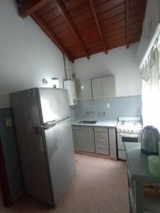 a kitchen with a stainless steel refrigerator and a stove at Casasodali in Villa Gesell