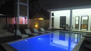 duży basen z niebieskim oświetleniem w domu w obiekcie WHITE SANDS RESORT w Gili Trawangan