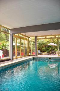 una piscina en una casa con ventanas en Piedras Doradas Hotel y Spa en Valeria del Mar