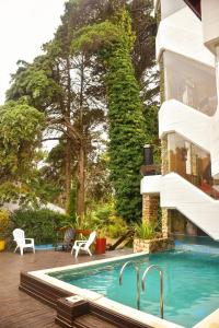 una casa con piscina al lado de un edificio en Piedras Doradas Hotel y Spa en Valeria del Mar