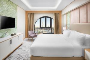 una camera d'albergo con un grande letto e una finestra di Taiba Suites Madinah a Medina