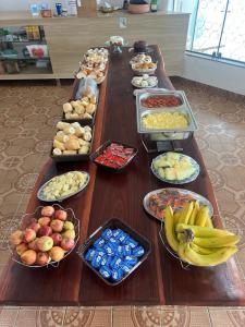una lunga tavola piena di diversi tipi di alimenti di Solar Grego Pousada Ubatuba a Ubatuba