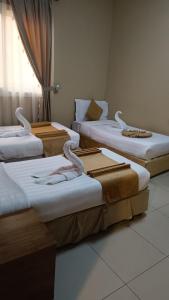 un grupo de tres camas en una habitación en Razana Al-Hafaer, en La Meca