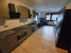 een keuken met roestvrijstalen apparatuur en een eettafel bij Pension Alex in Bielefeld +20 foto's