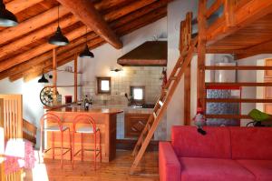 a living room with a red couch and a kitchen at Maison Chez Les Roset in Arvier