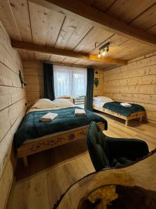 a bedroom with two beds in a log cabin at Pokoje i Apartamenty Regionalny Styl ul Bachledy 20 Zakopane in Zakopane