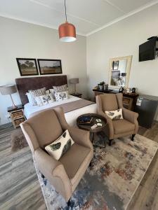 a bedroom with a bed and a couch and chairs at Jonkershoek Guest Farm in Kimberley